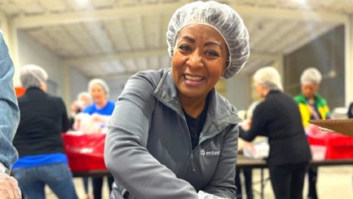 A smiling volunteer in a hair net.