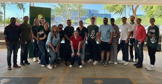 A group posed in front of a Northern Trust table and banner.