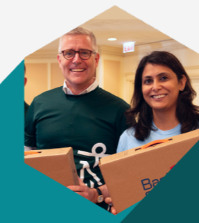 Two smiling people holding boxes.