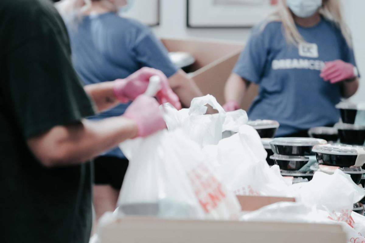 Volunteers packing food item in boxes.