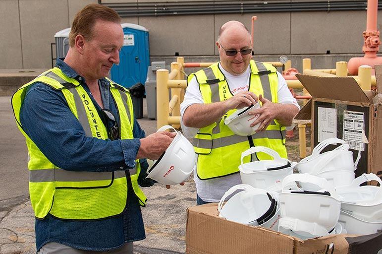 Two volunteers getting hard hats.