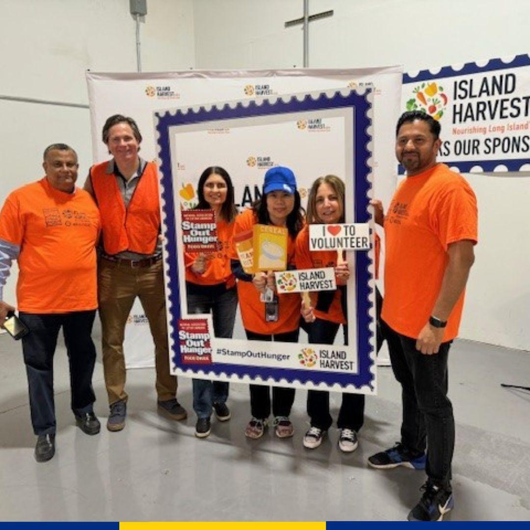 A group of volunteers "Island Harvest" sign behind them.