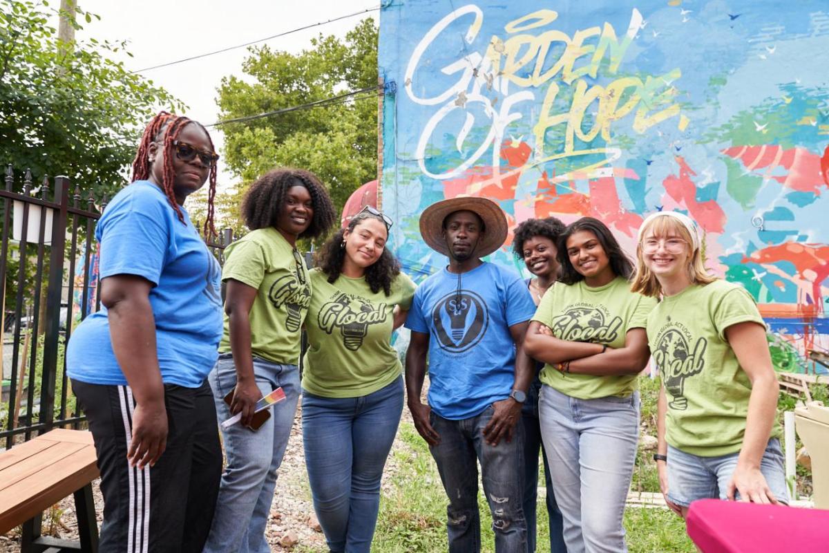 Seven people posing together in a garden: "Garden of Hope"