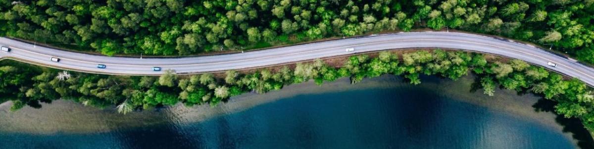 Aerial view of cars on a winding coastal road.