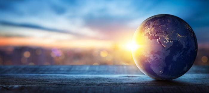 Model of the Earth sitting on a shelf with sunlight reflecting on the front of the globe.