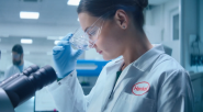 A person putting on protective eye wear in a lab setting.