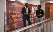 The Dean and a student smiling and talking as they walk through a hall way at the school.