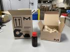 Two boxes with the MilliporeSigma logo and a small brown vial on a table in a warehouse