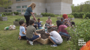 Teacher and students working together on a garden bed